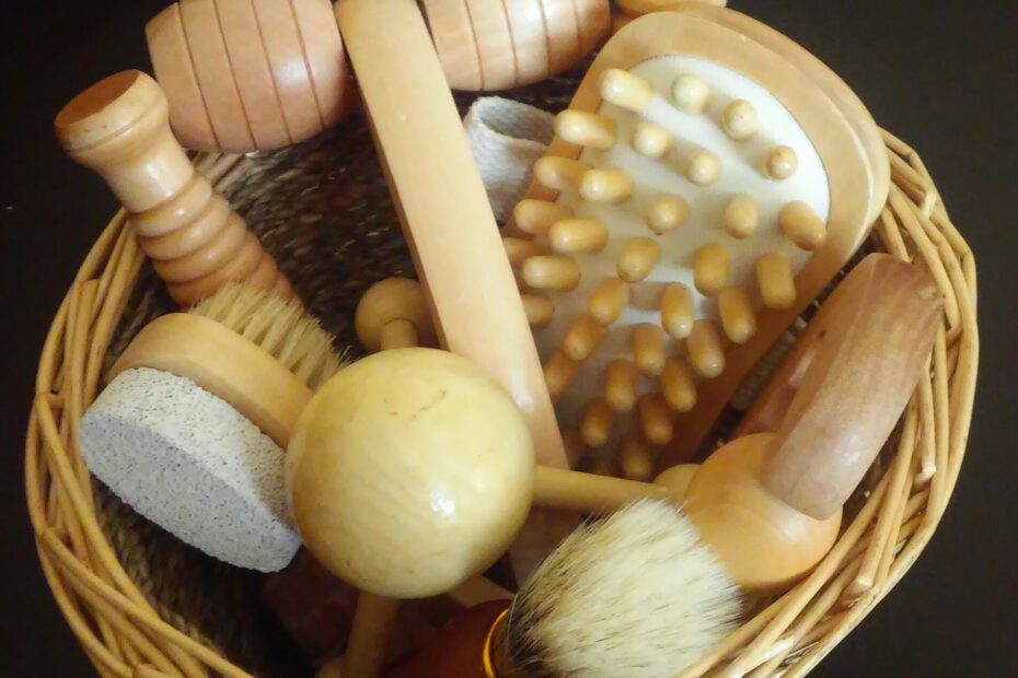 A collection of wooden massage tools and brushes in a woven basket.